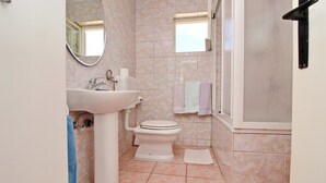 A bathroom with a sink, toilet, and a window. - Apartment Pehar (Orebic)