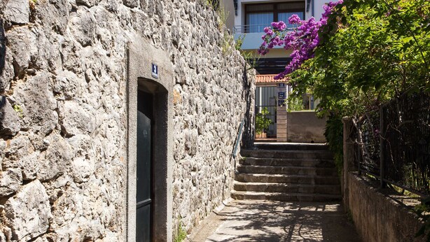 Um caminho de pedra estreito que leva a um edifício com uma porta marcada '8'.