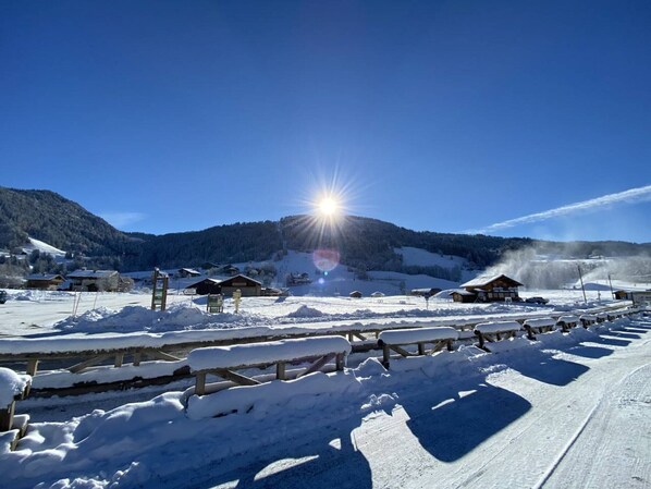 A snow-covered outdoor area with wooden benches and a wooden fence.