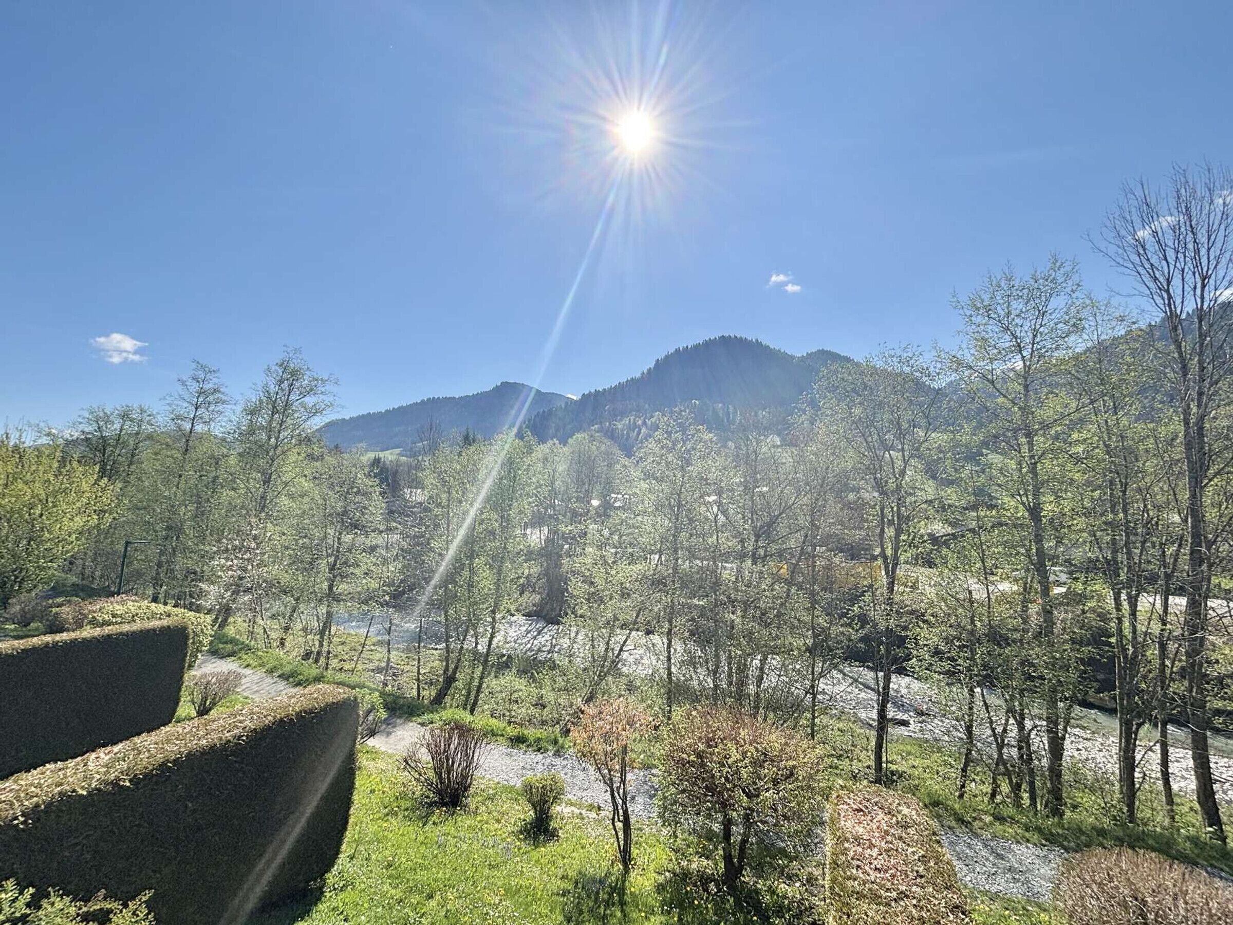 A mountainous landscape with a clear sky and sunlight.