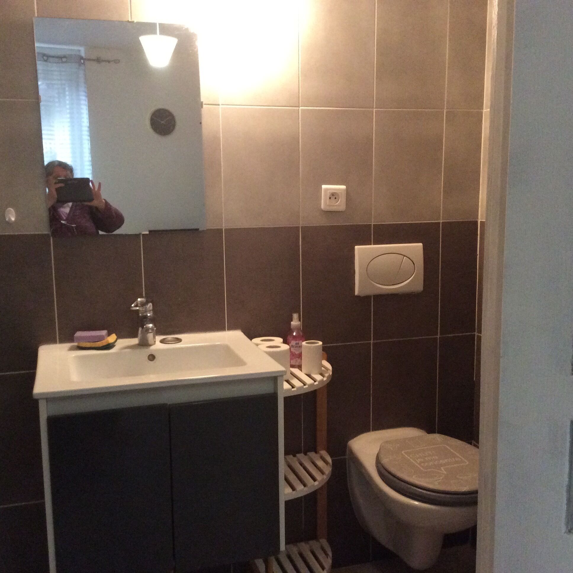 A bathroom with a sink, mirror, toilet, and a towel rack.