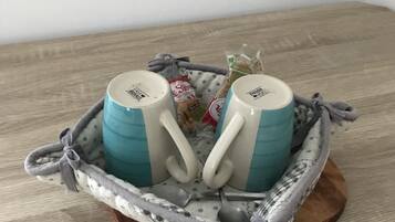 Two mugs with handles, placed on a wooden tray with a cloth.