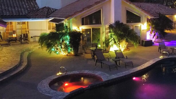 A house with a swimming pool, outdoor seating, and a hot tub.