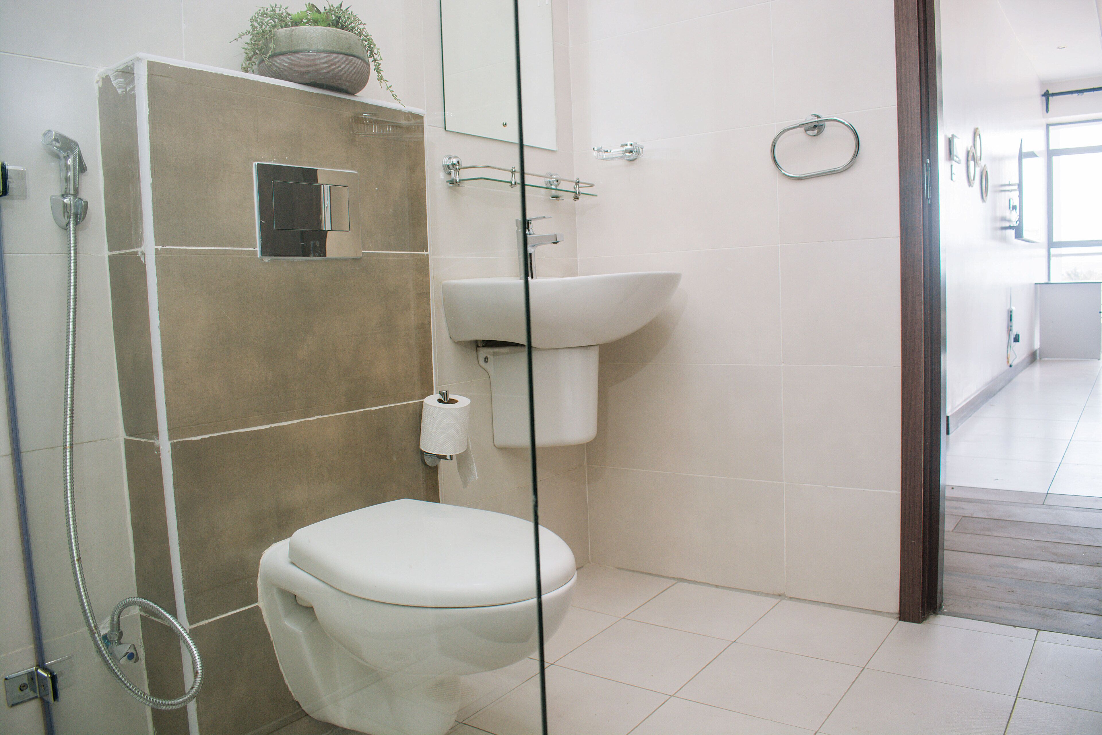 Une salle de bain moderne équipée de toilettes, d’une douche et d’un lavabo.
