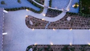 Vue aérienne d’un espace aménagé comprenant des allées, des aires de repos et un bâtiment.