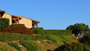 A modern house with a sloped roof, surrounded by well-maintained gardens and a clear blue sky. - Mini-villa T2 - Résidence Terra Théa**** (Propriano)