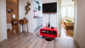 A modern living room with a red entertainment unit, a flat-screen TV mounted on the wall, and a wooden floor. - Apartment Nostalgija Split (Split)