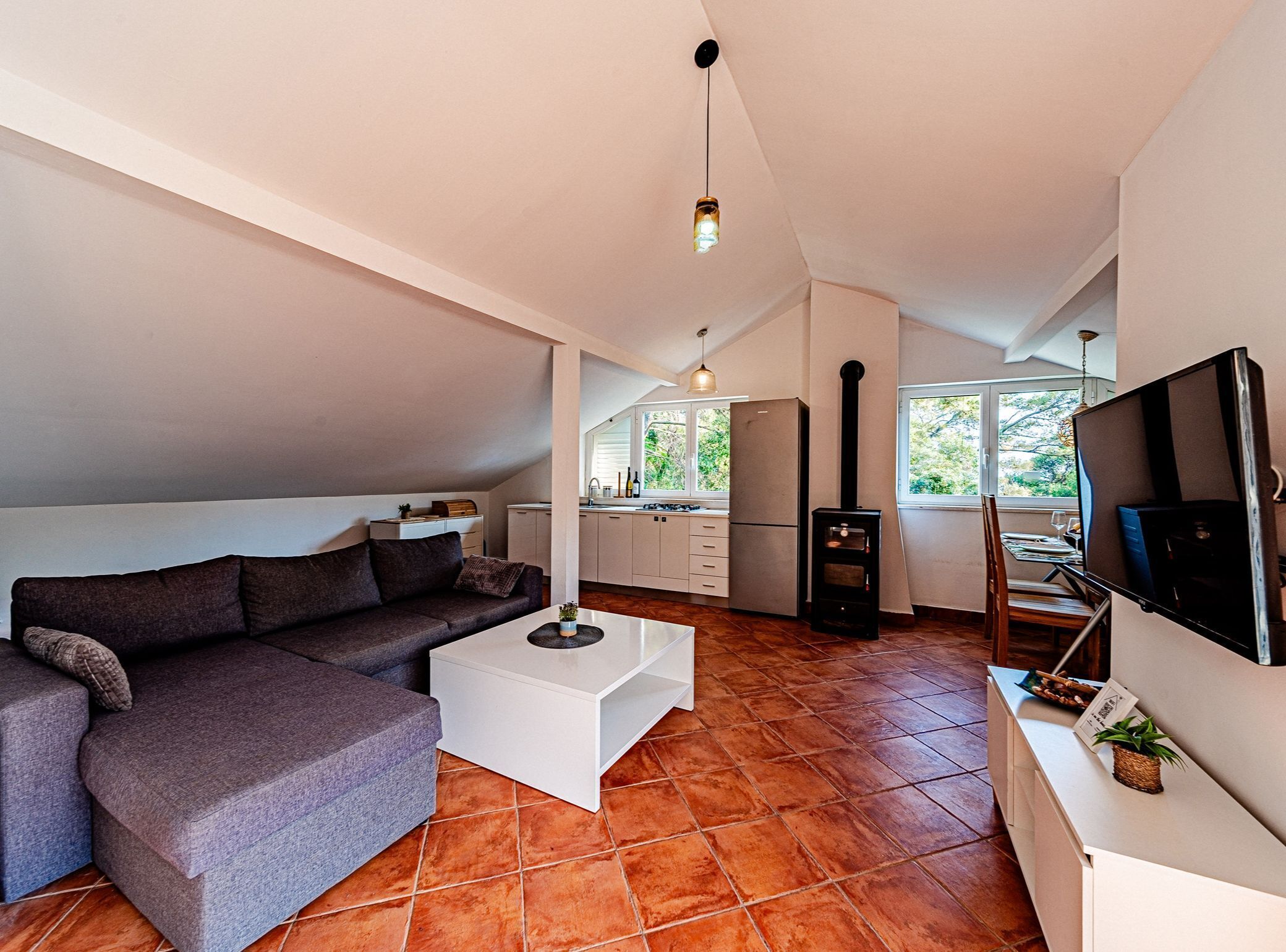 A modern living space with a sofa, coffee table, and a TV on a stand.