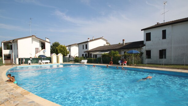 A swimming pool surrounded by houses with a clear sky.