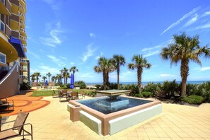 Relax by the pool surrounded by palm trees and ocean views.