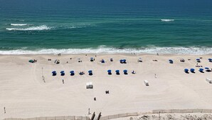 Una playa con sombrillas azules y una orilla arenosa.