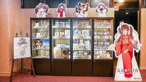 A display of anime merchandise with glass cases and cutout figures. - Aso Uchinomaki Onsen Daikanso (Aso)
