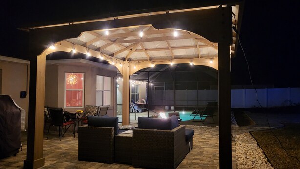Un patio extérieur couvert, doté d’un espace salon et d’une piscine.