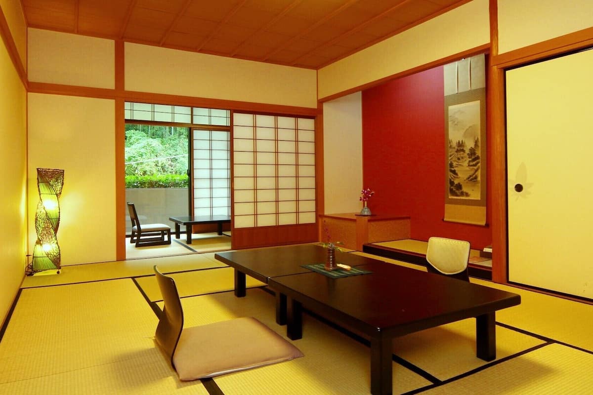 A traditional Japanese room with tatami flooring, a low table, and sliding doors.