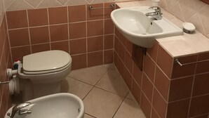 A bathroom with a toilet, bidet, and sink. - Small villa in a great location (Viareggio)
