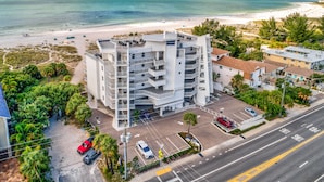 A multi-story hotel with a parking lot and a view of the beach. - ☀️Oceana 202 West☀️Beachfront☀️Private Balcony☀️Direct Beach Access (Treasure Island)
