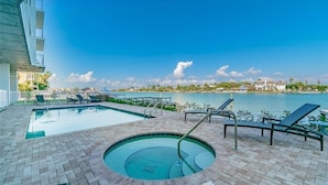 A pool area with a hot tub, lounge chairs, and a view of the ocean. - ☀️Oceana 202 West☀️Beachfront☀️Private Balcony☀️Direct Beach Access (Treasure Island)