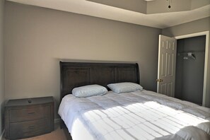 Une chambre à coucher avec un lit, une table de chevet et une porte.