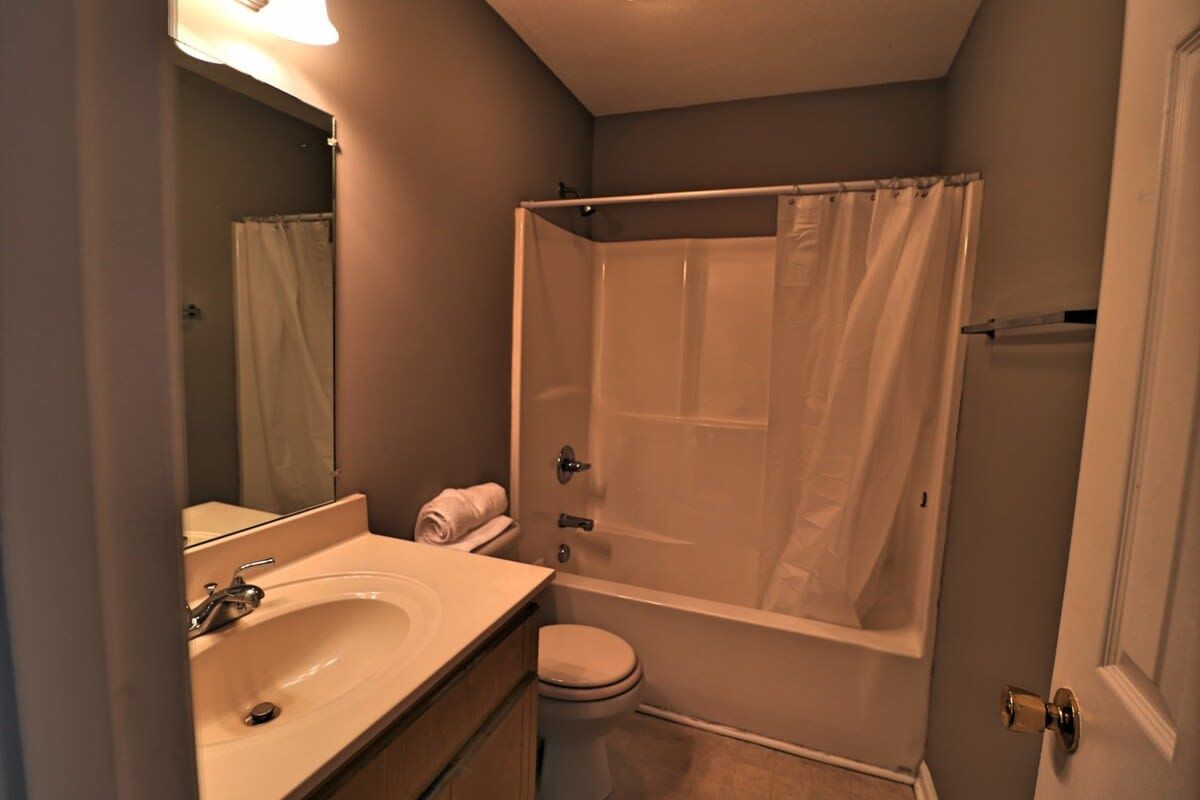 A bathroom with a bathtub, toilet, and sink.