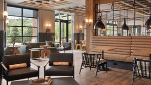 A modern interior with a large window, seating area, and wooden flooring. - The Eddy Taproom & Hotel (Golden)