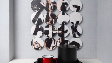 A modern room with a white table, a black tray with a red mug, and a wall-mounted circular decoration.