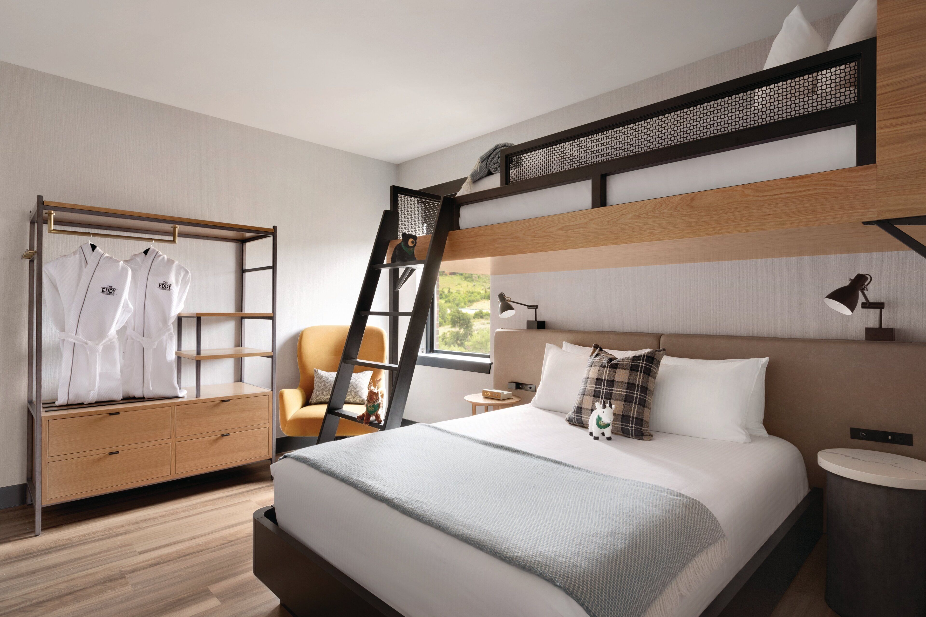 Une chambre moderne avec un lit superposé, une armoire en bois, un bureau et une chaise.