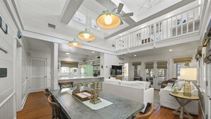 A spacious kitchen with a large island, wooden chairs, and pendant lighting. - Renovated in Seaside, Sleeps 12! 3 Minutes to Beach! + 2 Adult Bikes! (Santa Rosa Beach)