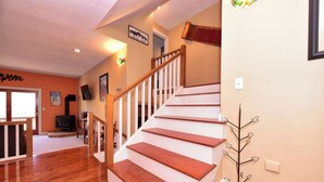 Eine Treppe mit Holzbodenstufen und weißen Geländern, die zu einer oberen Etage führt.