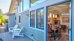 Ein Haus mit einer Terrasse, einem Essbereich mit Tisch und Stühlen sowie einer sichtbaren Küche.