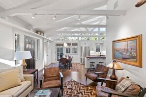 A spacious living area with a high ceiling, a dining table, and leather chairs. - Carmel's Wy Knot: Beautiful remodel in Carmel-by-the-Sea! (Carmel)