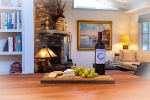 A wooden table with a bottle of wine, cheese, and grapes. - Carmel's Wy Knot: Beautiful remodel in Carmel-by-the-Sea! (Carmel)