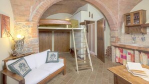 A cozy room with a wooden bench, a ladder, and a loft bed under an arched brick ceiling. - Giovanna apartment on two levels overlooking the swimming pool (Castel San Gimignano)