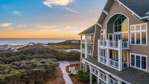 A multi-story building with balconies overlooking a beach and ocean. - Gulf-Front Retreat with Panoramic Views (Watersound)