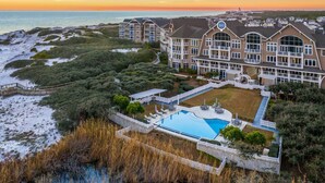 A beachfront hotel with a large pool, multiple balconies, and a view of the ocean. - Gulf-Front Retreat with Panoramic Views (Watersound)