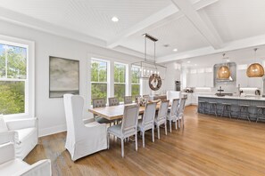 A spacious kitchen with a large island, white cabinetry, and a view of the outdoors.