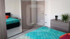 Een slaapkamer met een bed, een garderobe, een dressoir, een airconditioner en een klein plantje.