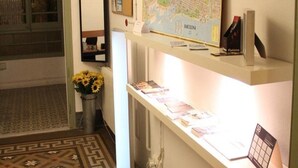 A reception area with a map of Barcelona, a vase with sunflowers, and a bulletin board with a sign. - Cosmopolitan Boutique Rambla (Barcelona)