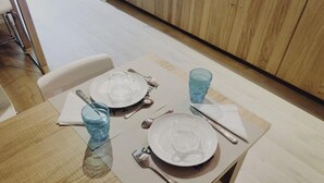 A dining table set with plates, cutlery, and blue glasses. - Cosmopolitan Boutique Rambla (Barcelona)