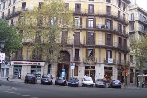 A multi-story building with a curved facade, featuring balconies and a ground-level entrance. - Cosmopolitan Boutique Rambla (Barcelona)