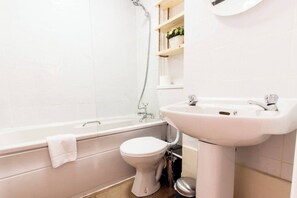 A bathroom with a bathtub, toilet, and sink.