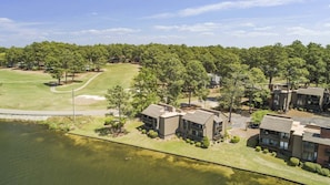 A residential area with modern houses, a golf course, and a lake. - Renovated, Lakefront, Pinehurst #5, Ground Level, 2BR, 2BA, Pool, WiFi, Cable (Pinehurst)