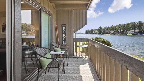 A balcony with outdoor seating, a view of a lake, and a sign reading "PORCH".