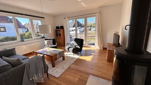 Ein geräumiges Wohnzimmer mit Kamin, einer Couch, einem Couchtisch und einem Bücherregal.