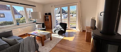 A spacious living room with a fireplace, a sofa, a coffee table, and a bookshelf.