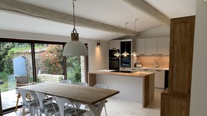 A modern kitchen with white cabinets, a wooden island, and pendant lighting. - Charming Mas in quiet Provence, between Luberon and Alpilles (Robion)