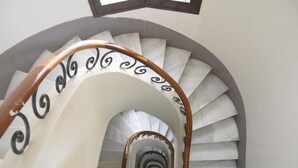A spiral staircase with a wooden handrail and black decorative elements. - Suite Home Sagrada Familia (Barcelona)