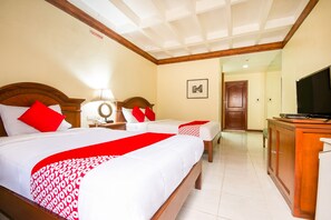 A hotel room with two beds, a television, a desk, and a cabinet. - Fords Inn Cebu (Cebu City)