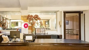 A reception desk with a computer, phone, and a sign indicating payment requirements.