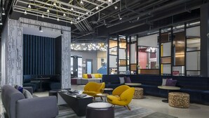 A modern lounge area with sofas, armchairs, and a coffee table. - Aloft by Marriott Dallas DFW Airport Grapevine (Coppell)