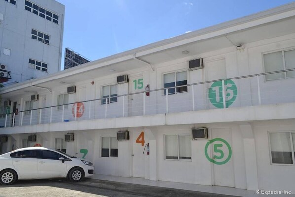 A multi-story building with numbered doors, likely a hotel or office building. - Islands Stay Hotel Mactan (Lapu-Lapu)